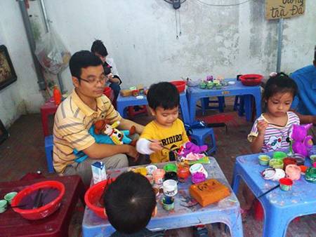 Kids in paint ceramic toys shop in Bat Trang pottery village